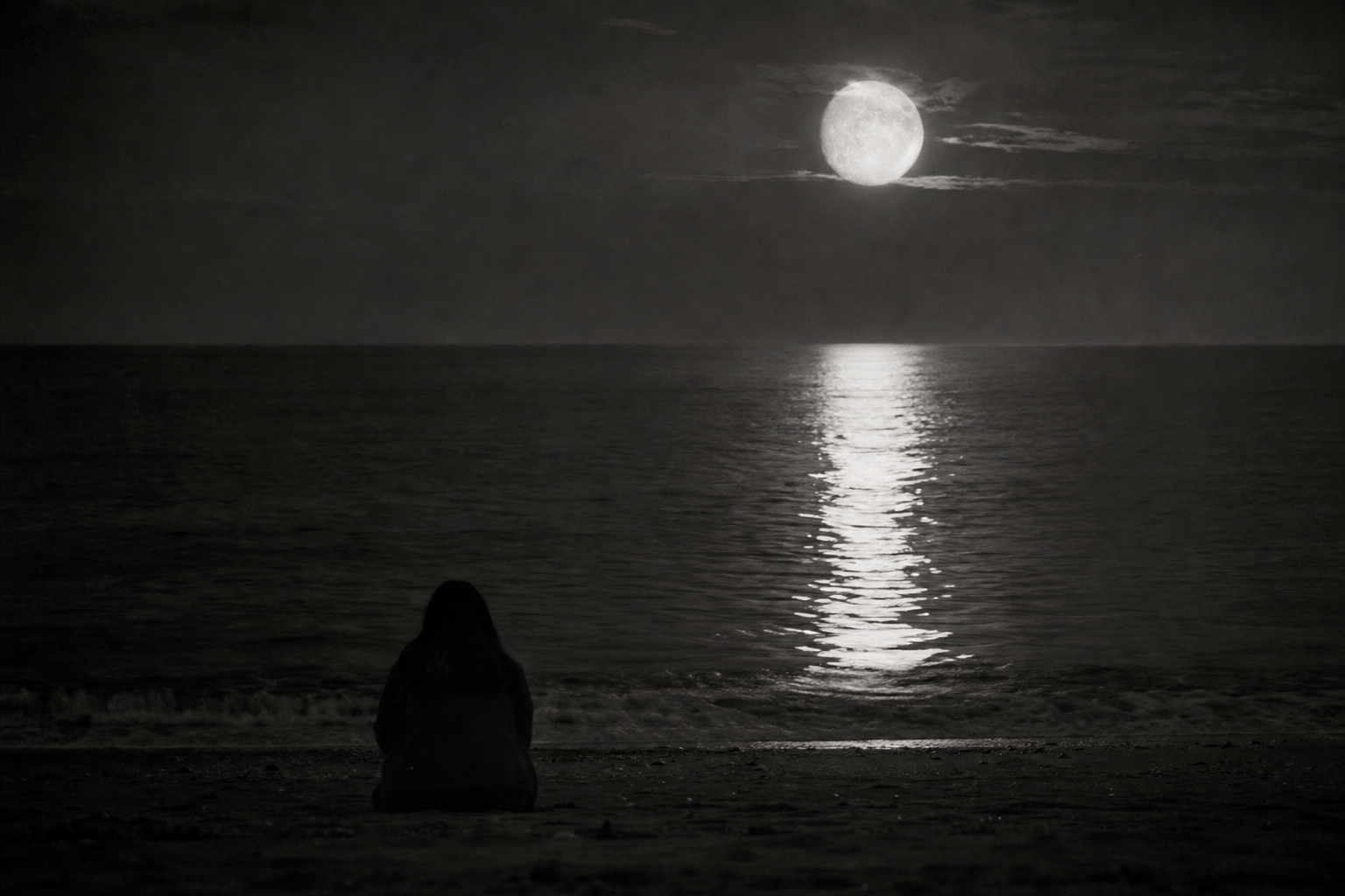 Dark moonlit sea beneath a partially eclipsed moon